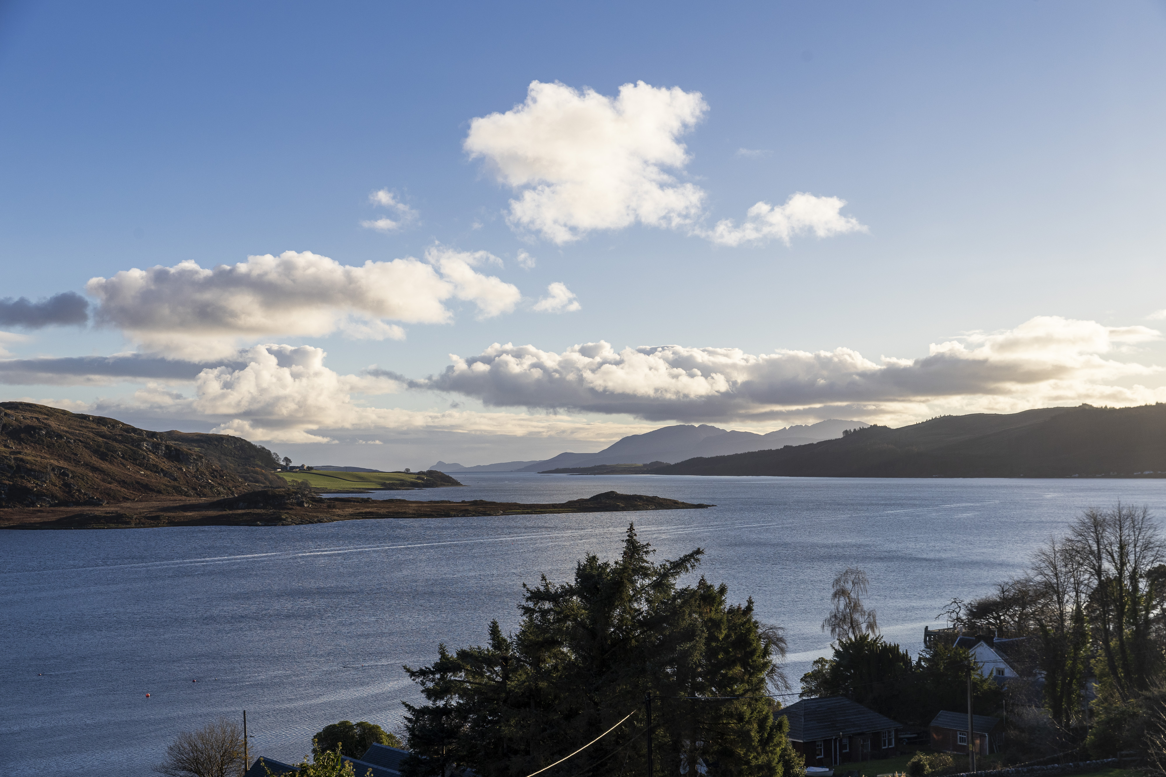 Scottish loch with green hills and white clouds